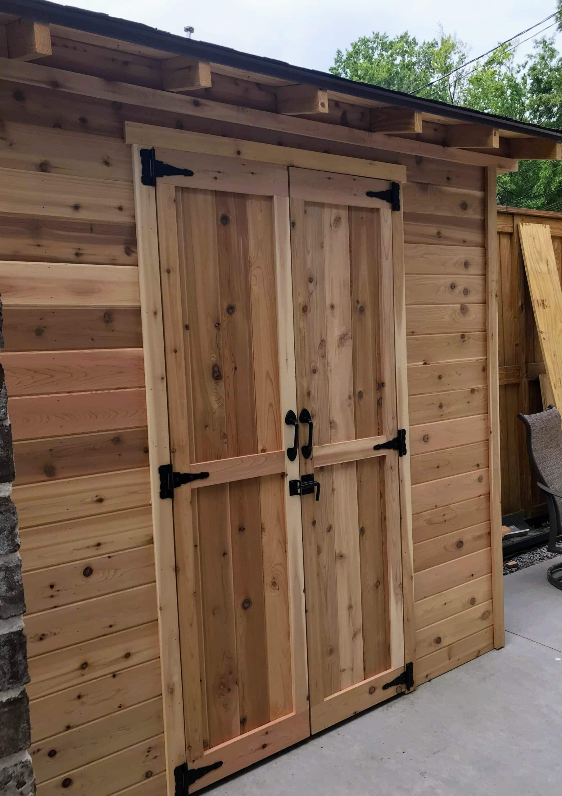 a wood sided shed with a shed roof on a concrete slab 