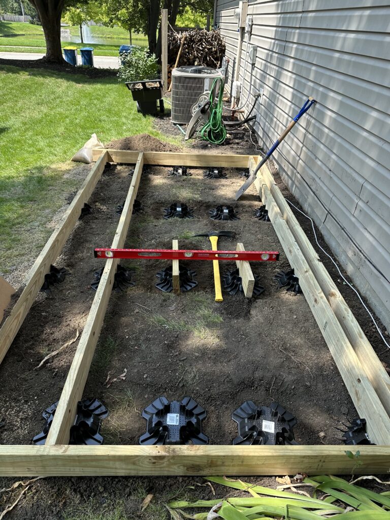 Leveling and placing the next floor joist. Long level across two joists to check for level front to back