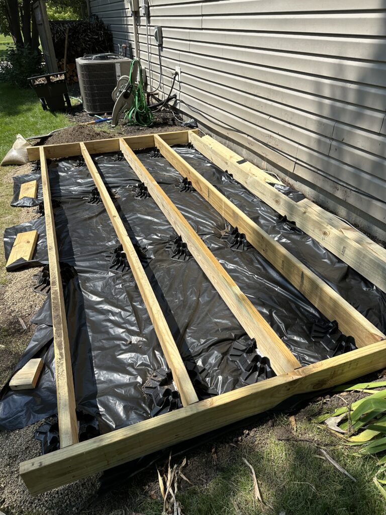 Vapor barrier installed beneath the inner rows of floor joists held down with boards because it was pretty windy