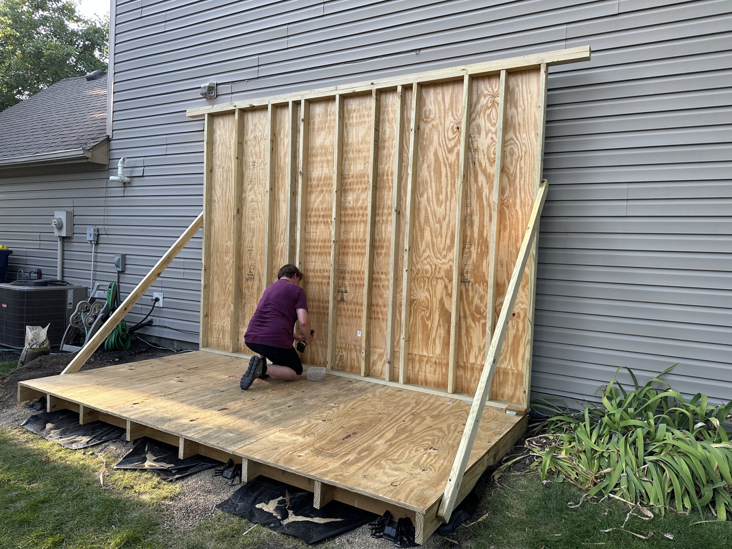 Back wall in place and braced; Rich is screwing the bottom plate to the floor joists