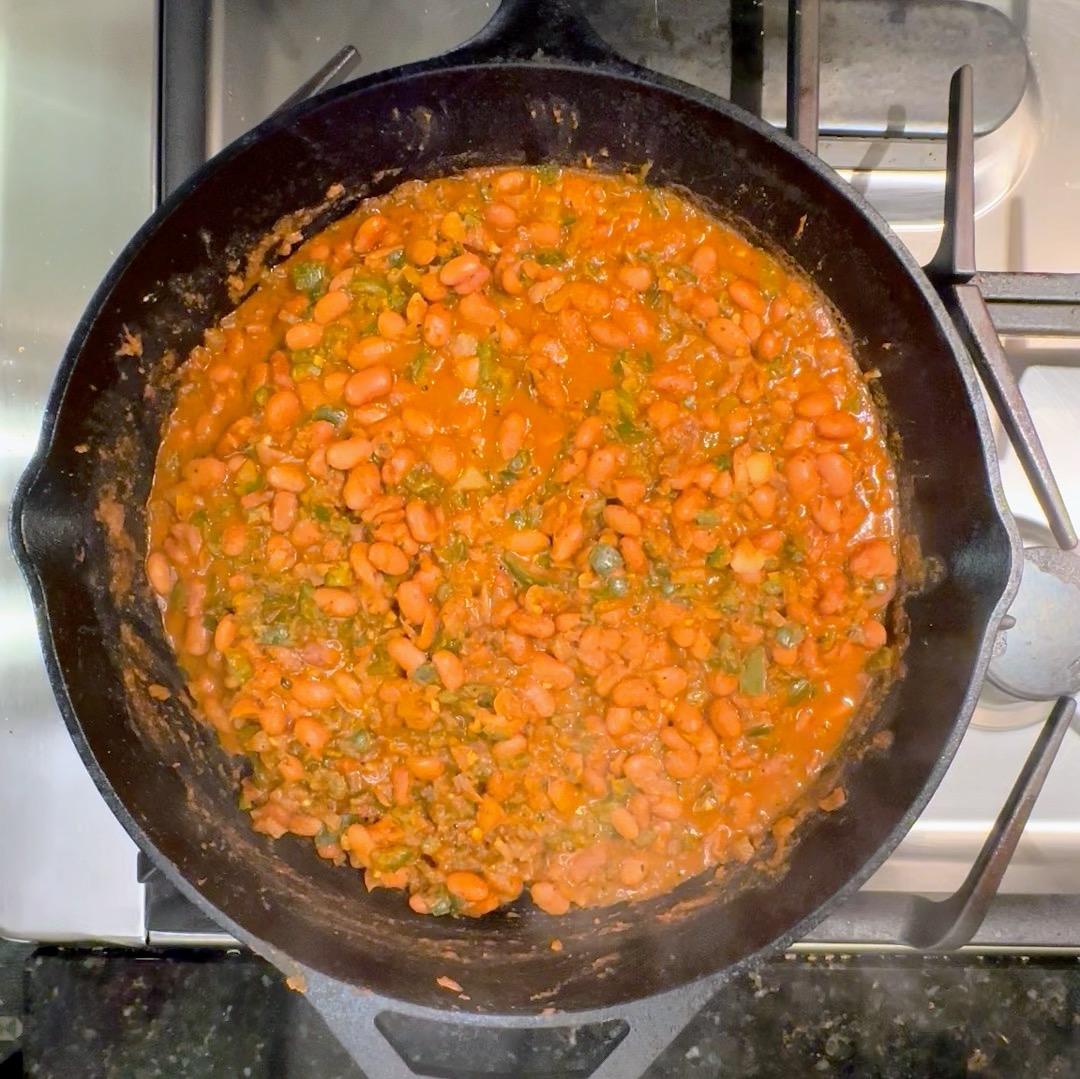 a cast iron skillet with braised pinto beans