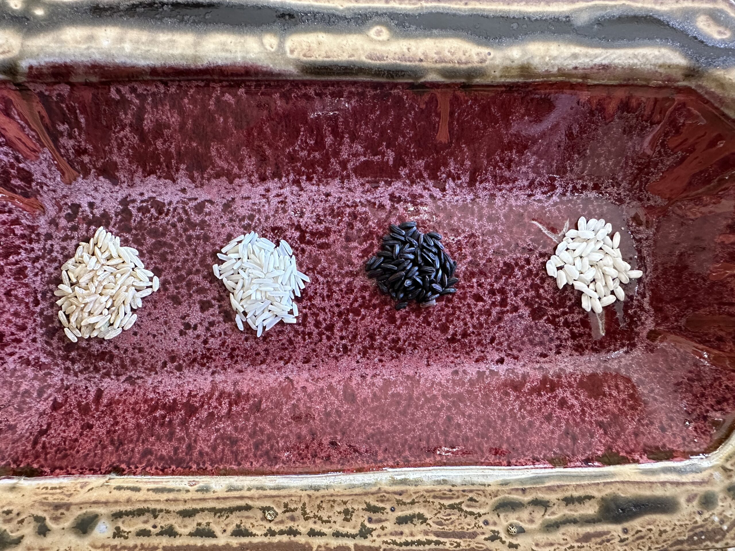 Uncooked rice on a red platter