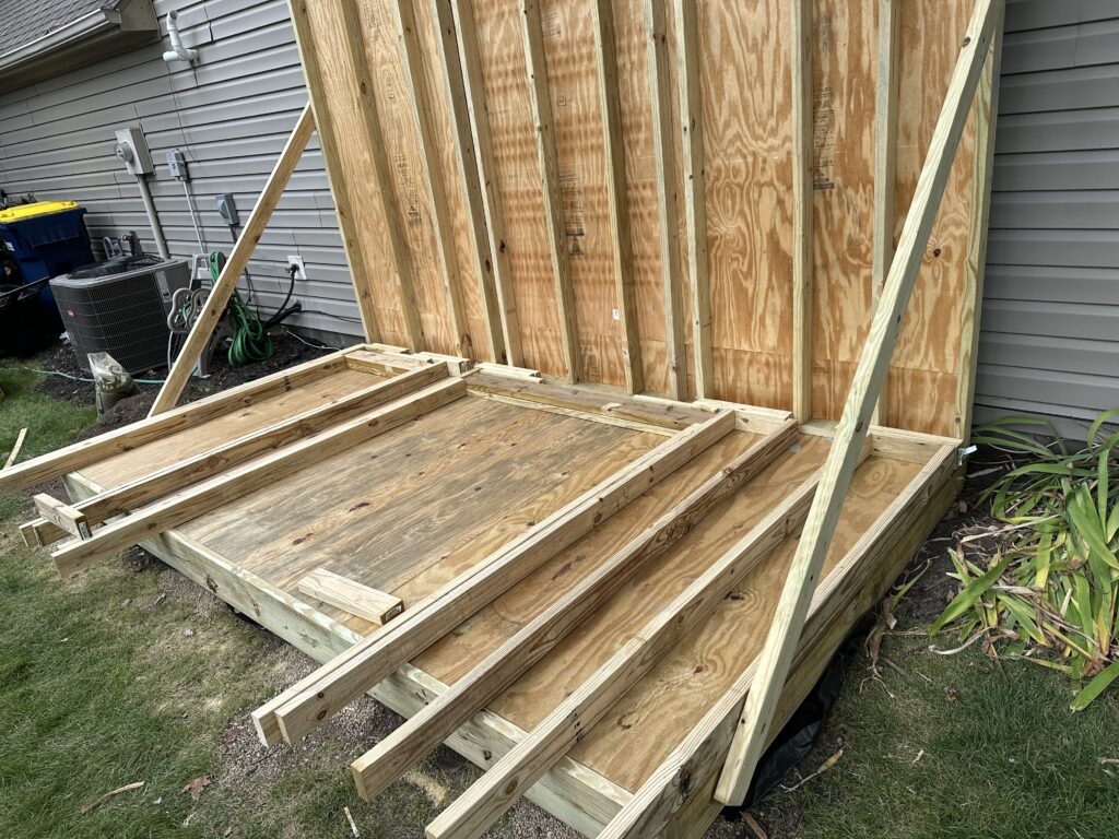 Pieces of the front wall laid out on the deck of the shed