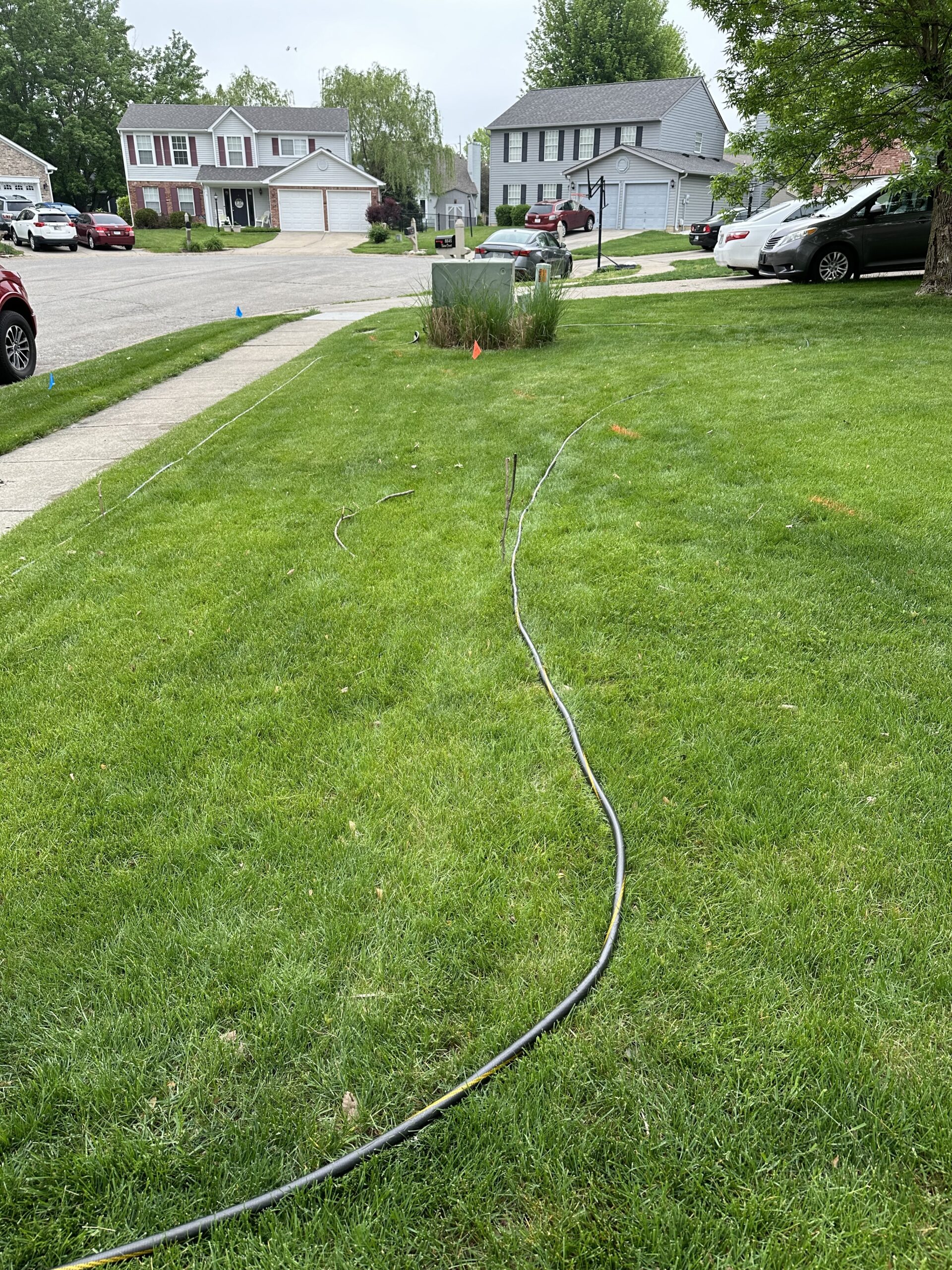 Rich and Katie's garden laid out with sticks to mark the arbor and a hose to mark the outline